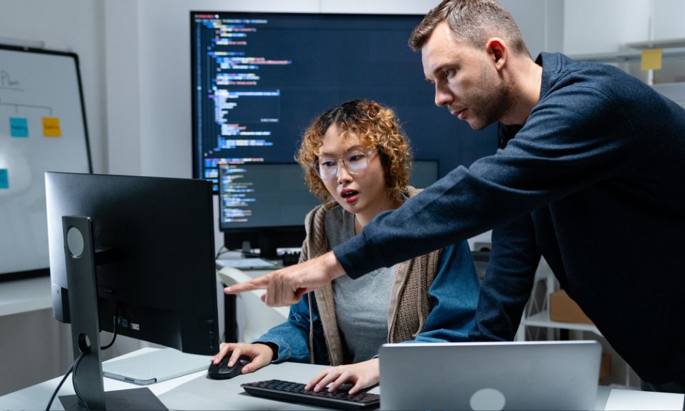 Person helping someone with code